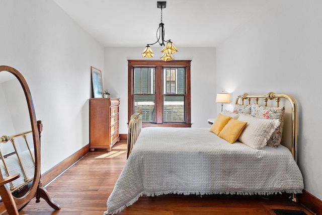 bedroom featuring baseboards and wood finished floors