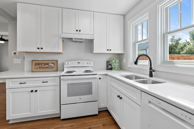 kitchen featuring under cabinet range hood, white cabinets, white appliances, and a sink