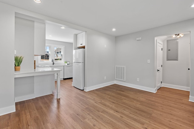 living room featuring visible vents, electric panel, recessed lighting, light wood-style floors, and baseboards