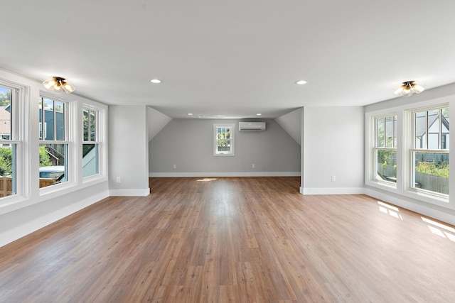 bonus room with recessed lighting, a wall mounted air conditioner, baseboards, and wood finished floors