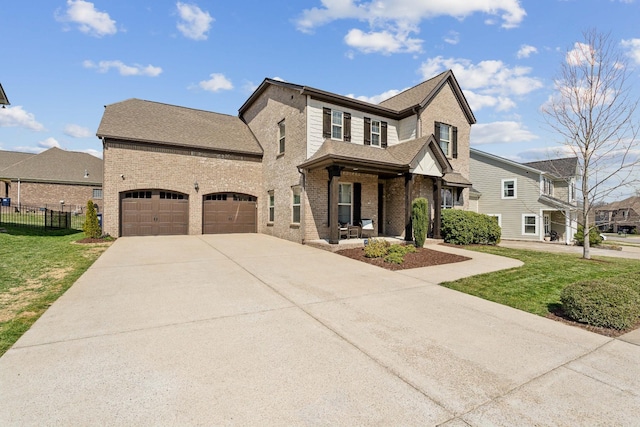 view of front of home featuring a front lawn, fence, brick siding, and driveway