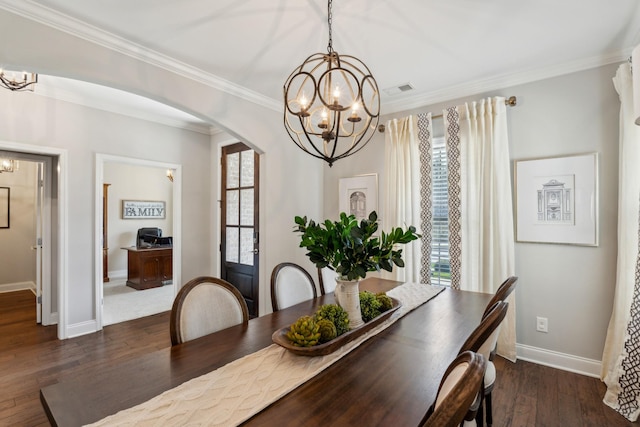 dining area featuring wood finished floors, baseboards, arched walkways, crown molding, and a notable chandelier