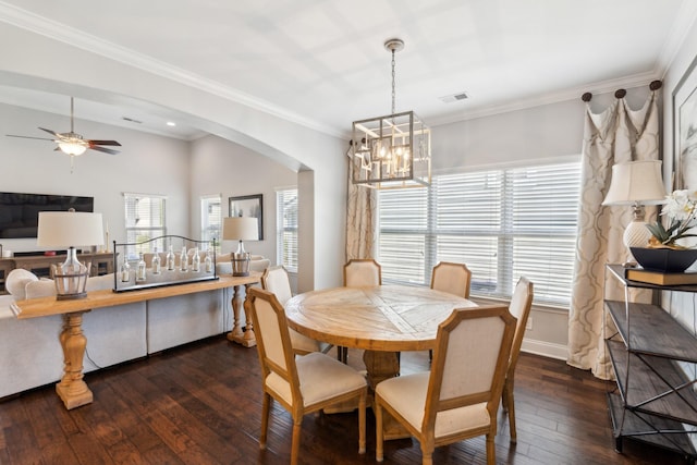 dining space featuring arched walkways, a healthy amount of sunlight, ceiling fan with notable chandelier, and hardwood / wood-style floors