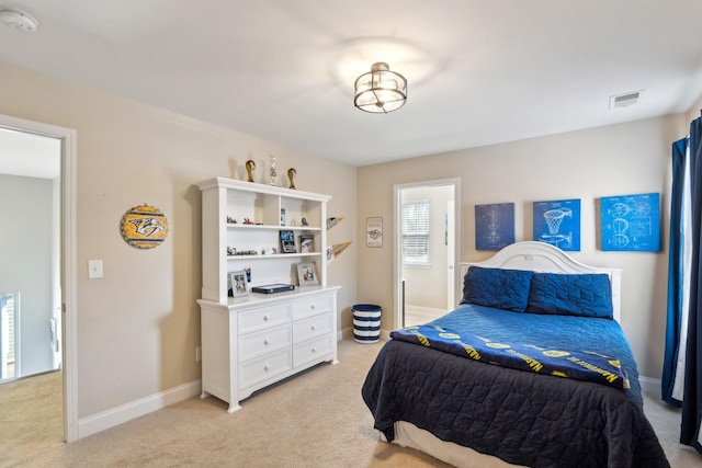 bedroom featuring visible vents, light colored carpet, and baseboards