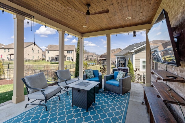 view of patio / terrace featuring a residential view, an outdoor living space with a fire pit, a ceiling fan, and fence