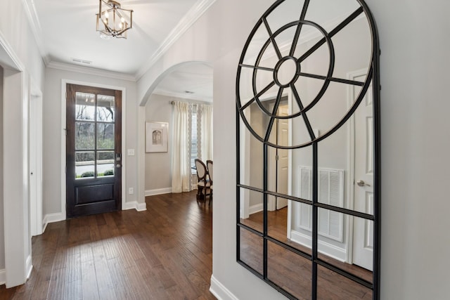 entryway featuring dark wood finished floors, crown molding, visible vents, and arched walkways