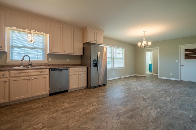 kitchen featuring a wealth of natural light, appliances with stainless steel finishes, baseboards, and a sink