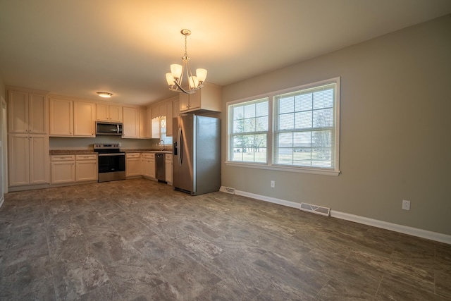 kitchen featuring stainless steel appliances, baseboards, a notable chandelier, and visible vents