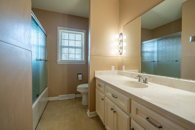 full bathroom featuring visible vents, toilet, combined bath / shower with glass door, baseboards, and vanity