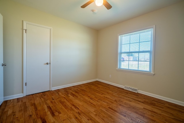 spare room with visible vents, baseboards, and wood finished floors