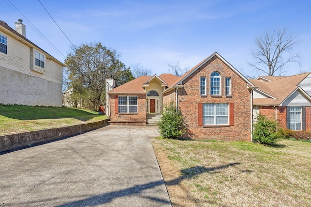 view of front facade with a front lawn, brick siding, and a chimney