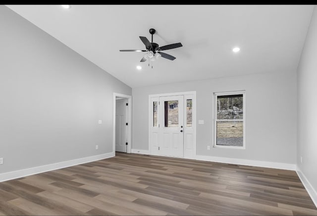 spare room featuring baseboards, wood finished floors, a ceiling fan, and vaulted ceiling