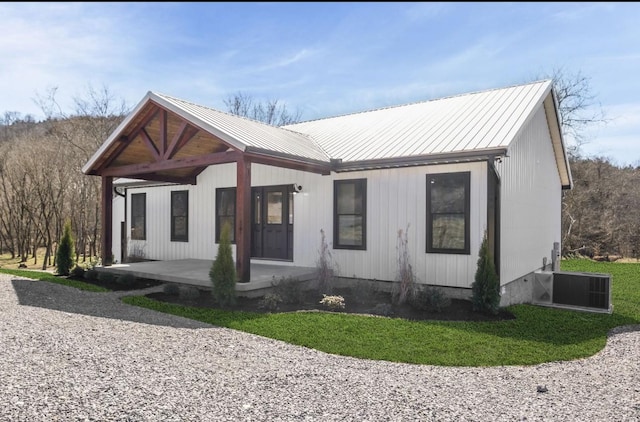 view of front of house featuring cooling unit, metal roof, and a standing seam roof