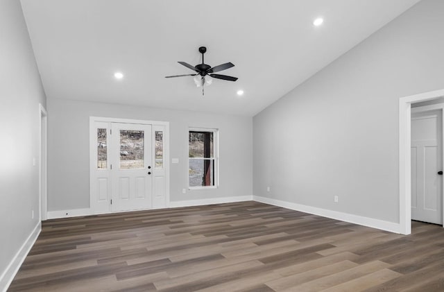 spare room featuring baseboards, lofted ceiling, and wood finished floors