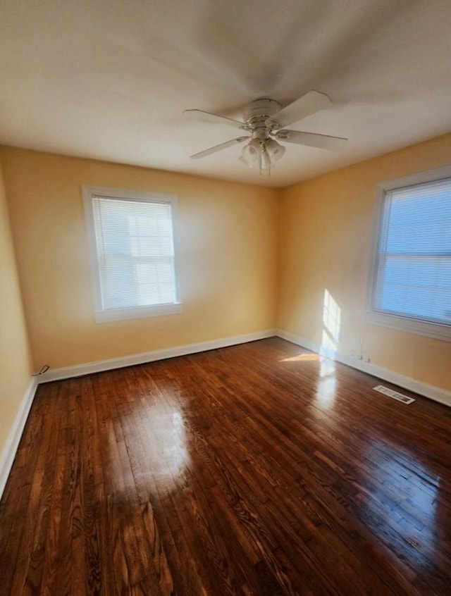 unfurnished room with baseboards, plenty of natural light, and wood finished floors