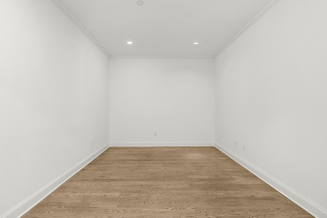 unfurnished room featuring recessed lighting, light wood-style flooring, crown molding, and baseboards