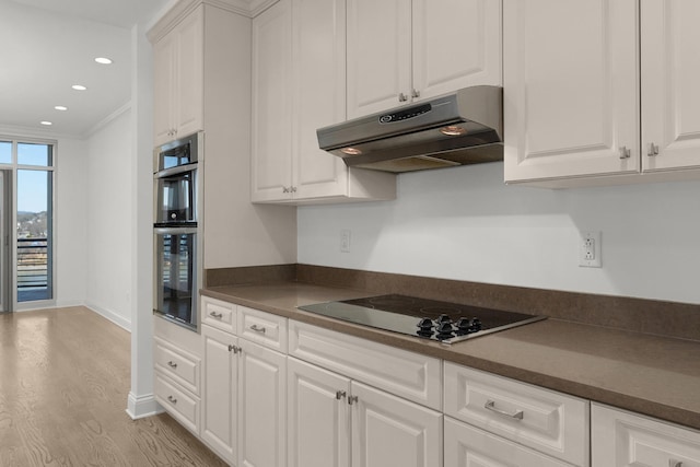 kitchen featuring stainless steel double oven, under cabinet range hood, white cabinetry, dark countertops, and black electric stovetop