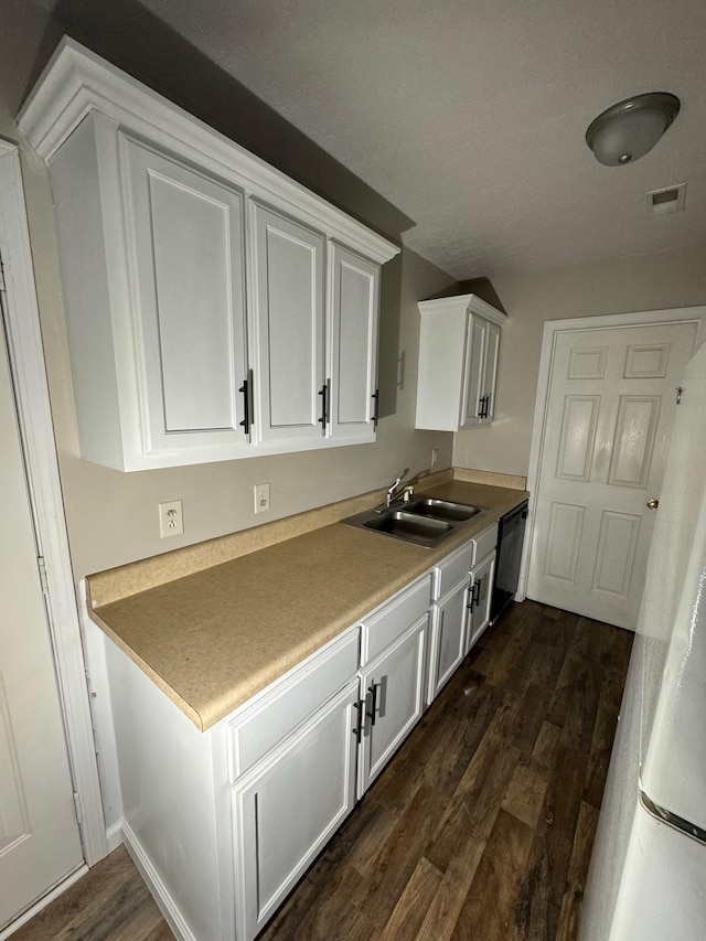 kitchen with a sink, black dishwasher, dark wood finished floors, white cabinetry, and light countertops