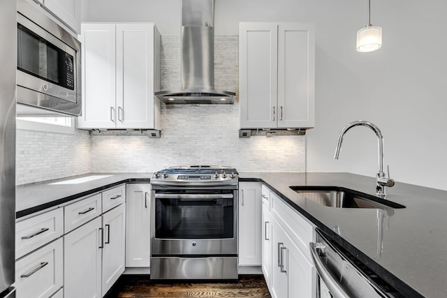 kitchen with a sink, backsplash, stainless steel appliances, white cabinets, and wall chimney range hood