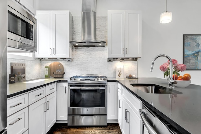 kitchen featuring a sink, appliances with stainless steel finishes, white cabinetry, wall chimney range hood, and backsplash