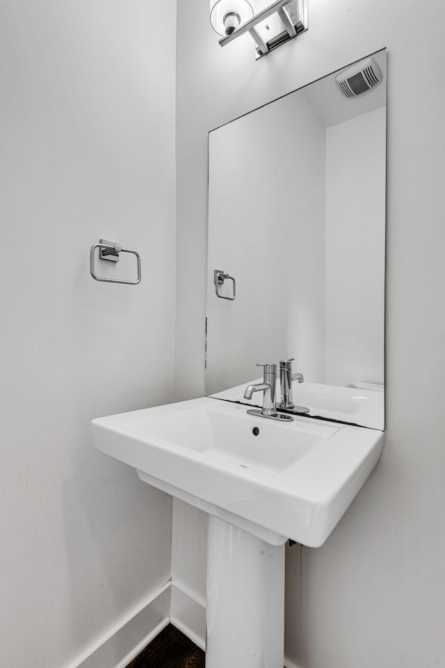 bathroom with visible vents, baseboards, and a sink