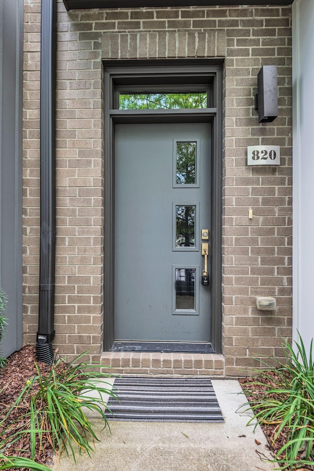 doorway to property featuring brick siding