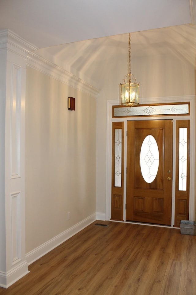 entrance foyer with a chandelier, baseboards, and wood finished floors