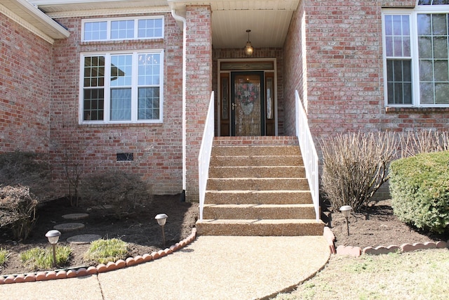 doorway to property with crawl space and brick siding