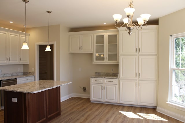 kitchen featuring white cabinetry, light wood-style floors, glass insert cabinets, baseboards, and light stone countertops