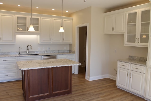 kitchen with wood finished floors, recessed lighting, a sink, white cabinets, and dishwasher