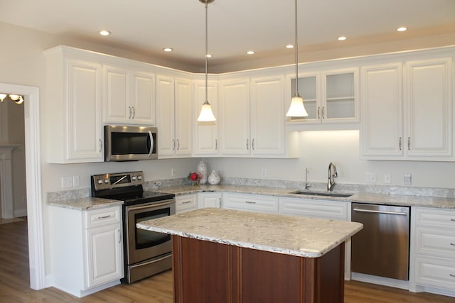 kitchen featuring a center island, recessed lighting, appliances with stainless steel finishes, white cabinets, and a sink