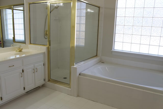 full bathroom with vanity, a garden tub, and a stall shower