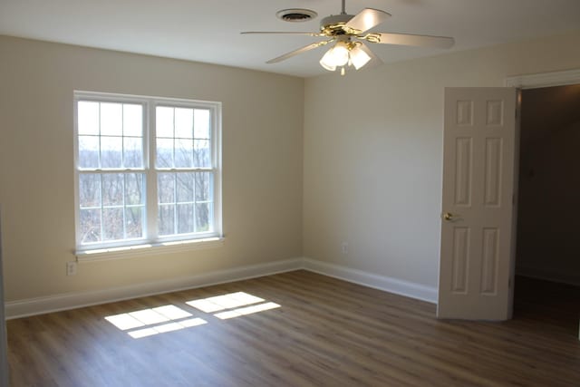 spare room with visible vents, baseboards, wood finished floors, and a ceiling fan