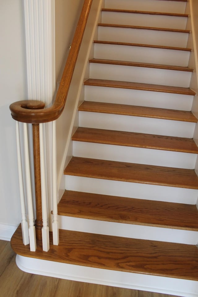 stairs featuring wood finished floors