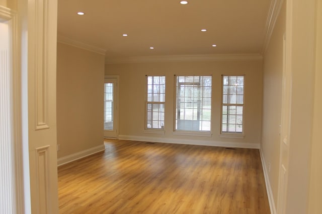 spare room with crown molding, recessed lighting, light wood-style floors, and baseboards