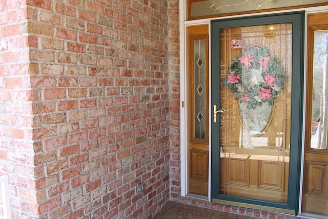 view of exterior entry featuring brick siding