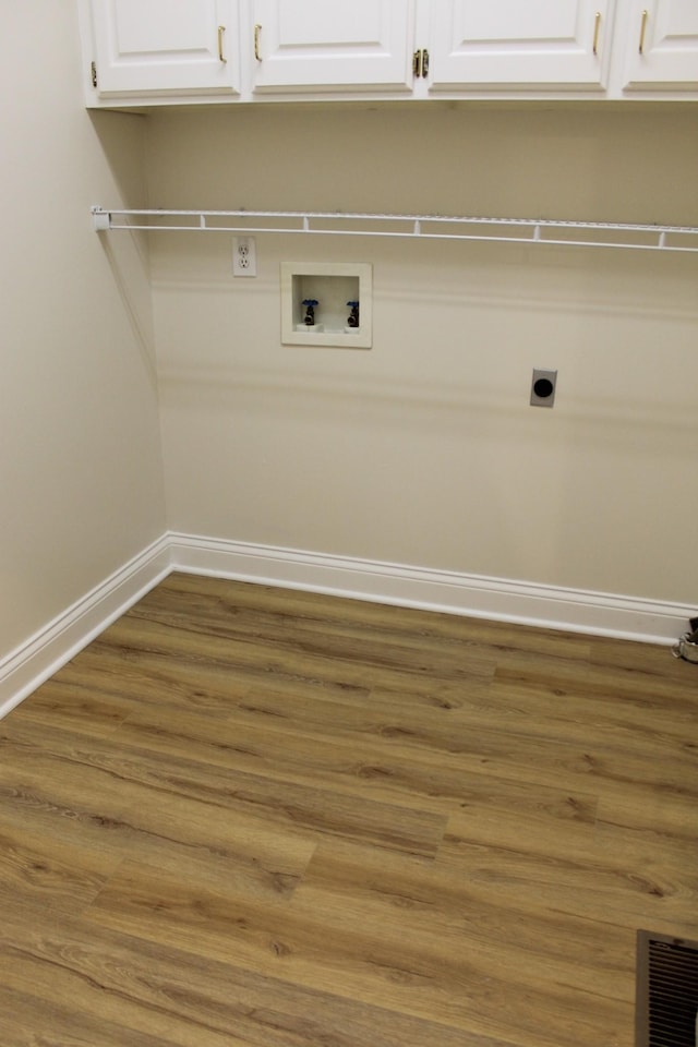 laundry room with wood finished floors, cabinet space, baseboards, hookup for an electric dryer, and hookup for a washing machine