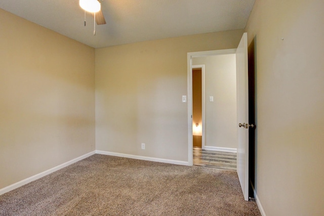 carpeted empty room with a ceiling fan and baseboards