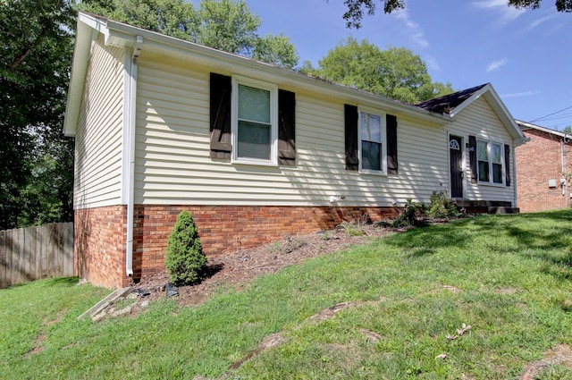 view of front of house with a front lawn, fence, and brick siding