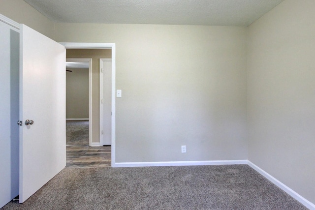 unfurnished room with baseboards, carpet floors, and a textured ceiling