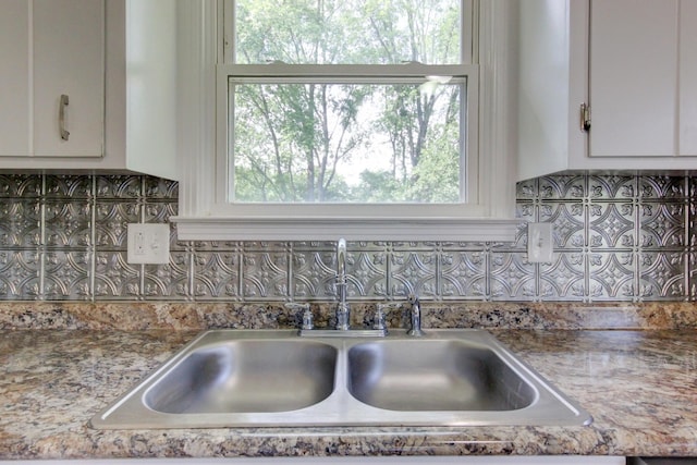 room details with white cabinetry and a sink