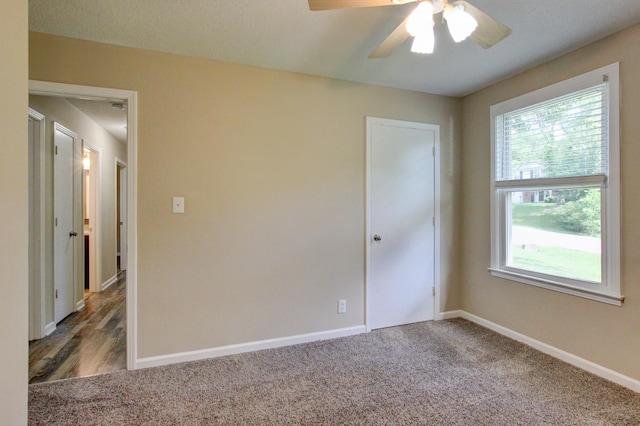 unfurnished room with carpet flooring, a ceiling fan, and baseboards