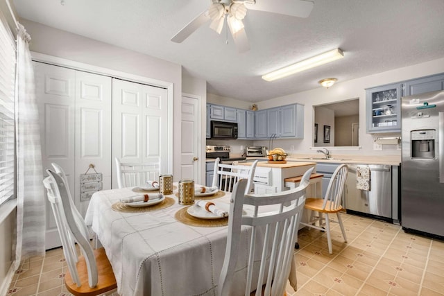 dining room with a textured ceiling, ceiling fan, and a toaster