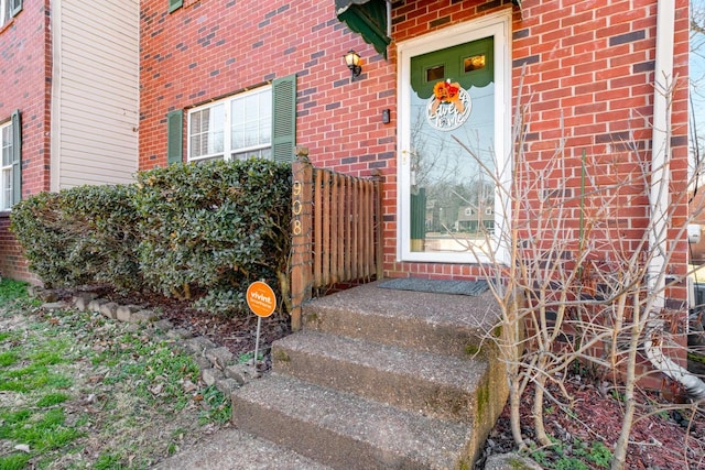 doorway to property featuring brick siding