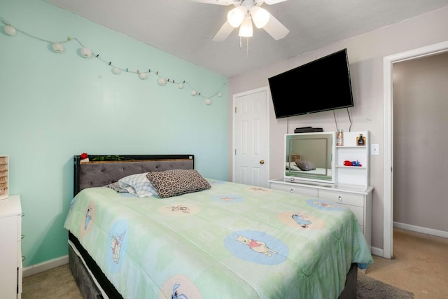 bedroom featuring baseboards, light colored carpet, and a ceiling fan