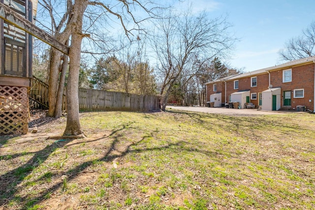 view of yard featuring central AC unit and fence