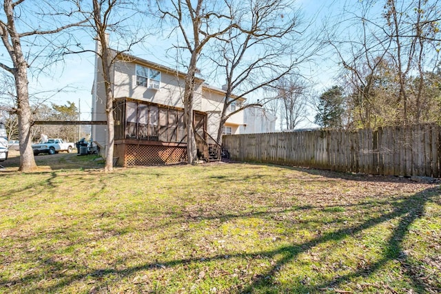 view of yard with fence and a sunroom