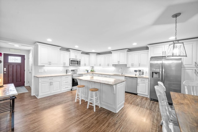 kitchen featuring white cabinetry, wood finished floors, and appliances with stainless steel finishes