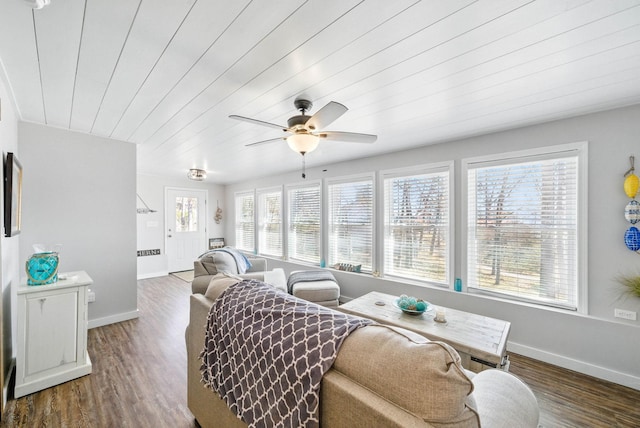 living area with a wealth of natural light, baseboards, and wood finished floors