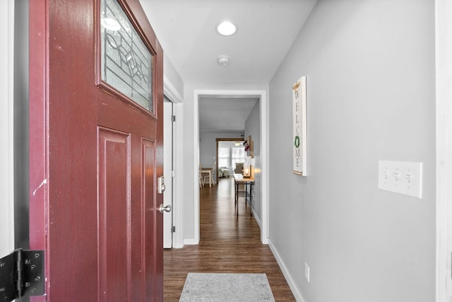 hall featuring baseboards and dark wood-style floors